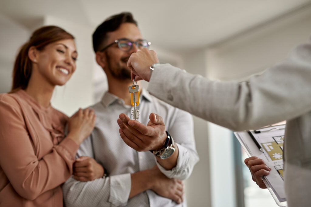 services-2 close up of real estate agent giving new house keys to a couple.